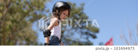 Girl in special outfit and helmet skating in park Girl in special outfit and helmet skating in park 101694973