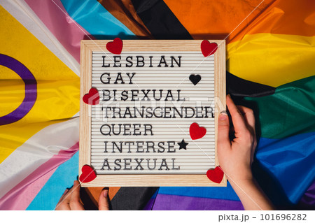 LGBTQIA description frame on Rainbow LGBTQIA flag made from silk material. LESBIAN, GAY, BISEXUAL, TRANSGENDER, QUEER, INTERSEX, ASEXUAL Symbol of LGBTQ pride month. Equal rights. Peace and freedom LGBTQIA description frame on Rainbow LGBTQIA flag made from silk material. LESBIAN, GAY, BISEXUAL, TRANSGENDER, QUEER, INTERSEX, ASEXUAL Symbol of LGBTQ pride month. Equal rights. Peace and freedom 101696282