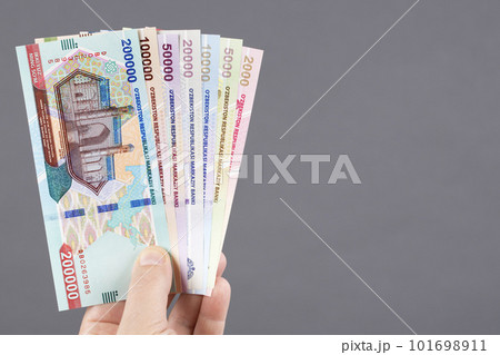 Uzbek money in hand on a gray background 101698911