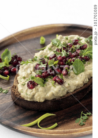 Baba ghanoush eggplant dip and pomegranate seeds on toast 101701089
