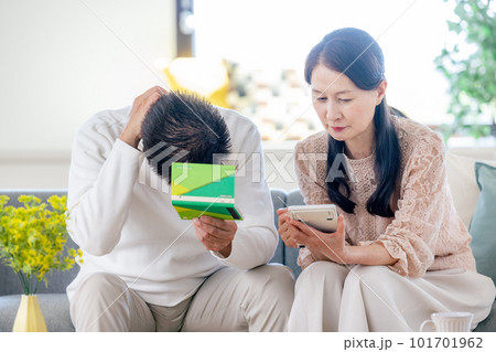 年金手帳を見るシニアの夫婦 年金手帳を見るシニアの夫婦 101701962