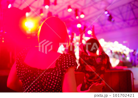Woman dancing during concert against neon light 101702421