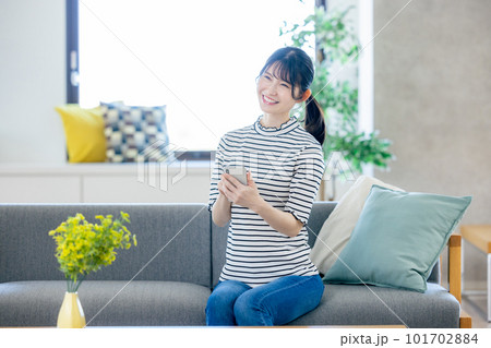 リビングでスマホを見る若い女性 リビングでスマホを見る若い女性 101702884