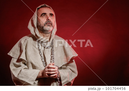 A wandering monk with a chain around his neck reads prayers 101704456