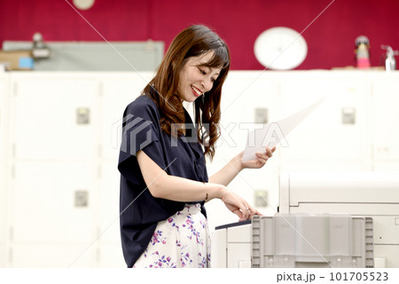 プリンターの前で書類を持つ女性 101705523