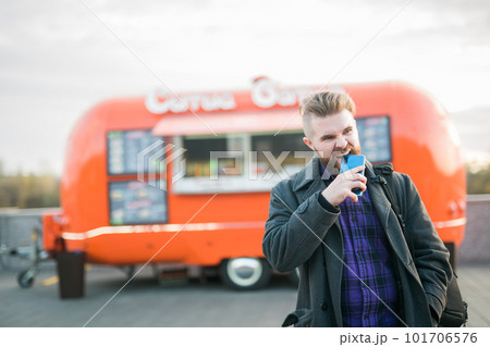 Angry hungry man bites smartphone on background food truck - hunger and lack of money Angry hungry man bites smartphone on background food truck - hunger and lack of money 101706576