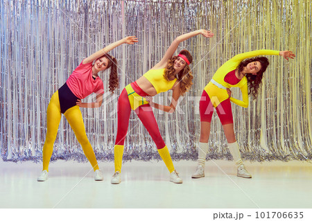 Sportive, active, young women in colorful, comfortable sportswear training, doing stretching and aerobics exercises. Slim fit body Sportive, active, young women in colorful, comfortable sportswear training, doing stretching and aerobics exercises. Slim fit body 101706635