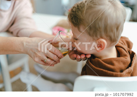 Grandmother giving glass of water to little grandson. Grandmother giving glass of water to little grandson. 101707992