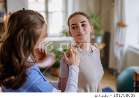 Teenage girl doing exercise with a nurse. 101708008