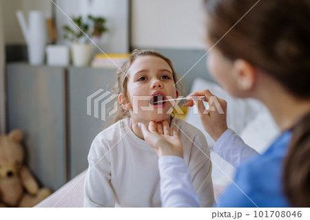 Young doctor taking care of little girl in hospital room. 101708046