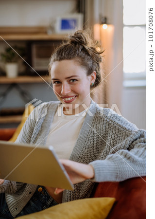 Young woman with digital tablet resting in her apartment. Young woman with digital tablet resting in her apartment. 101708076
