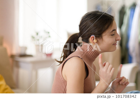 Portrait of teenage girl with hearing aid in her room. 101708342