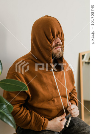 Depressed unhappy man covered hood her face - escapism and loneliness mental problem concept. Bipolar disorder and melancholy 101708749