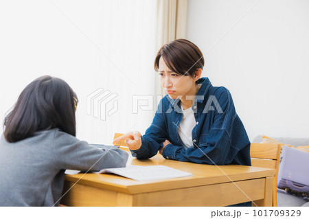 リビングで宿題をする小学生とお母さん　 101709329