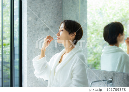 歯磨きするバスローブの女性 101709378