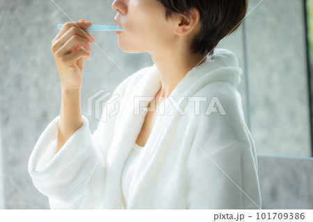 歯磨きするバスローブの女性 101709386
