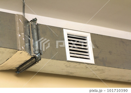 Ventilation pipes in silver insulation material hanging from the ceiling inside new building. Ventilation pipes in silver insulation material hanging from the ceiling inside new building. 101710390