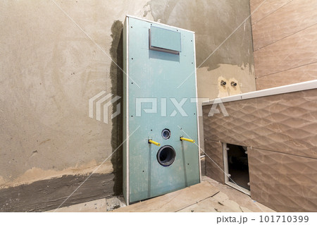 Unfinished reconstruction of bathroom or toilet with ceramic tiles installed on walls of drywall, place for lavatory and bath. Unfinished reconstruction of bathroom or toilet with ceramic tiles installed on walls of drywall, place for lavatory and bath. 101710399
