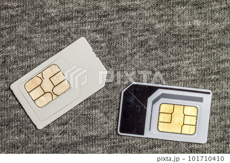 Two simcards isolated on grey cloth texture background Two simcards isolated on grey cloth texture background 101710410