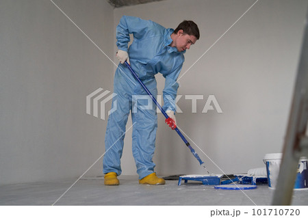 Man paints the ceiling with a roller Man paints the ceiling with a roller 101710720