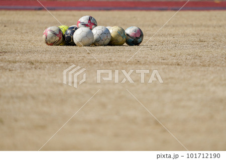 冬の枯れた芝生の上に集められたサッカーボール 冬の枯れた芝生の上に集められたサッカーボール 101712190