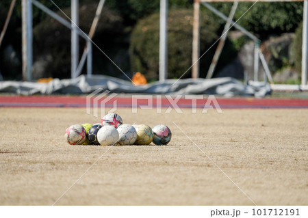 冬の枯れた芝生の上に集められたサッカーボール 101712191
