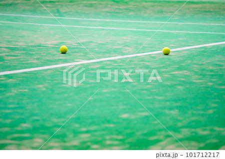 テニスの試合中にコートの端に転がったテニスボール 101712217