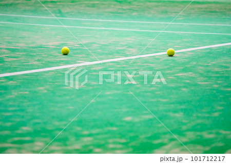 テニスの試合中にコートの端に転がったテニスボール 101712217