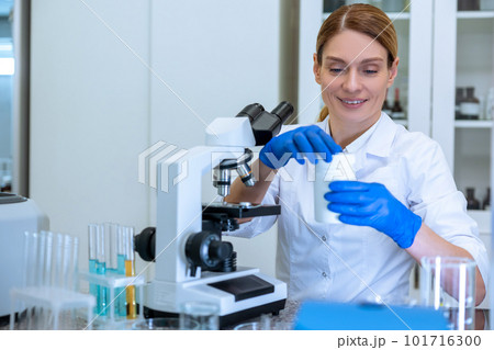 Female scientist in lab coat and gloves using microscope microbiologist working in modern laboratory Female scientist in lab coat and gloves using microscope microbiologist working in modern laboratory 101716300
