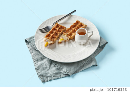 Oatmeal Belgian waffles in pencil shape on blue table 101716338