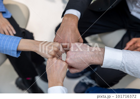 Close up of people holding hands during therapy session Close up of people holding hands during therapy session 101716372