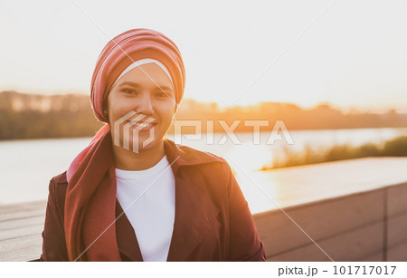 Young Arabic muslim woman in hijab walking at street seafront copy space and place for advertising 101717017