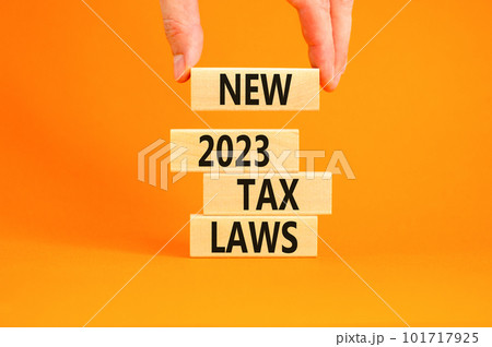 New 2023 tax laws symbol. Concept words New 2023 tax laws on wooden blocks. Beautiful orange table orange background. Businessman hand. Business new 2023 tax laws concept. Copy space. 101717925