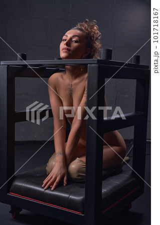 Seductive naked female in bondage cage in darkness Seductive naked female in bondage cage in darkness 101718167