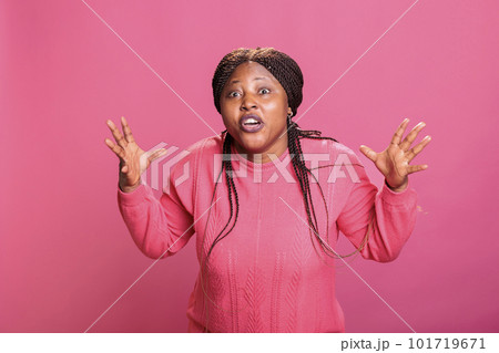 African american model feeling frustrated and aggressive while posing in studio over pink background. Furious stressed woman having mental breakdown showing unpleasant reaction. 101719671