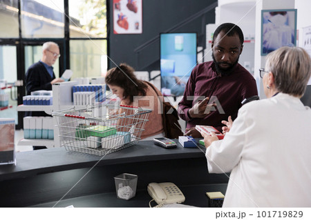 African american pharmacy customer discussing with pharmacist asking details about pills before buying it in drugstore. Worker helping client with medical prescription, health care service support African american pharmacy customer discussing with pharmacist asking details about pills before buying it in drugstore. Worker helping client with medical prescription, health care service support 101719829