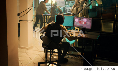Skilled hacker successfully cracking security network on computer, doing hacking and espionage work at night. Male criminal being congratulated about cryptojacking achievement. Skilled hacker successfully cracking security network on computer, doing hacking and espionage work at night. Male criminal being congratulated about cryptojacking achievement. 101720130