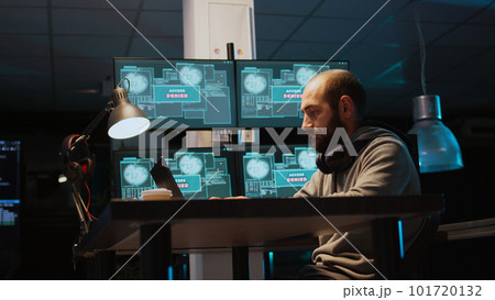 Aggressive violent hacker trying to hack network in office, feeling mad about hacking system failure. Dealing with hardware error trying to steal server information, irritated thief. Handheld shot. 101720132