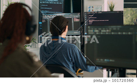 Database programer writing code on terminal window using multiple monitors in it agency office. System software developer typing database information, computing big data script. Database programer writing code on terminal window using multiple monitors in it agency office. System software developer typing database information, computing big data script. 101720360