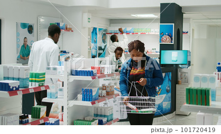 Female client taking boxes of pills and vitamins from drugstore, buying medicaments for healthcare. Young woman checking supplements and pharmaceutical products, medical store. Female client taking boxes of pills and vitamins from drugstore, buying medicaments for healthcare. Young woman checking supplements and pharmaceutical products, medical store. 101720419