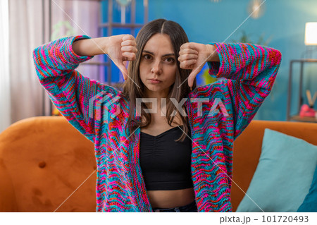 Upset Caucasian woman showing thumbs down dislike bad work disapproval dissatisfied feedback at home 101720493