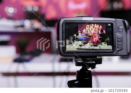 Content creator recording podcast talking with subscribers discussing lifestyle advice filming vlog in creative studio. Asian influencer live streaming using professional vlogging equipment 101720593