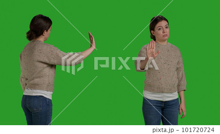 Close up of negative adult showing rejection gesture with palm, expressing disapproval and refusal symbol. Young person doing stop talking sign with hand, disagreement and reject on green screen. Close up of negative adult showing rejection gesture with palm, expressing disapproval and refusal symbol. Young person doing stop talking sign with hand, disagreement and reject on green screen. 101720724