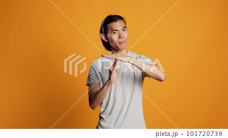 Young adult doing t shape symbol on camera, showing break or pause sign for denial and refusal. Asian casual guy expressing rejection and asking for half time, body language concept. 101720739