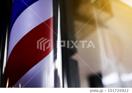 Barber pole spinning at night. International barbershop pole sign. A barber pole calling for people at street. Vintage barbershop. Salon. 101720922