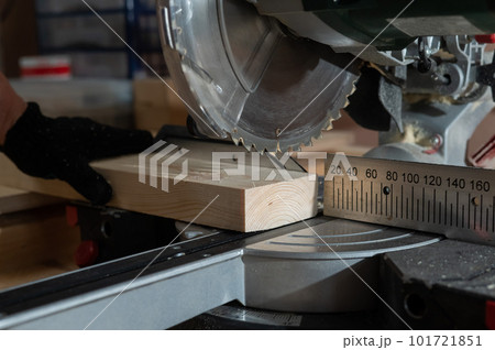 The master cuts the board with a circular saw in the workshop. Close-up of a carpenter's male hands at work. The master cuts the board with a circular saw in the workshop. Close-up of a carpenter's male hands at work. 101721851