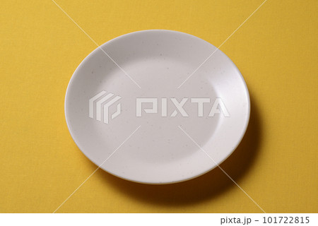 黄色い背景に置かれた梨地の皿 101722815