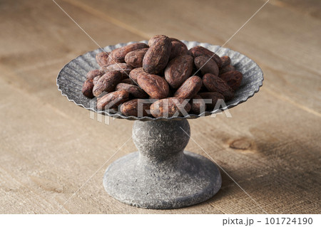 アンティークなコンポート皿に盛られたカカオビーンズ 101724190