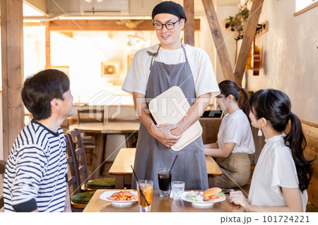 常連客とおしゃべりをするカフェ・飲食店のホールスタッフ・従業員の男性 101724221