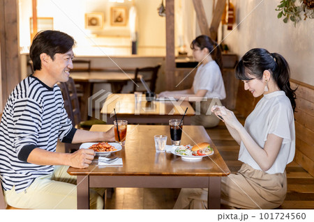 カフェ・レストランにデートできたスマホで料理を撮影するカップルのアジア人の男女 101724560